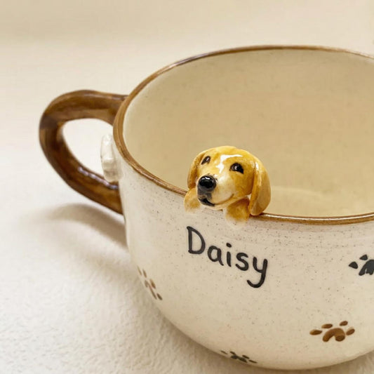Ceramic mug with a dog-shaped handle and 'Daisy' engraved on it.