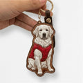 Custom Leather Pet Portrait Keychain with a dog design wearing a red jacket held by a hand on a white background