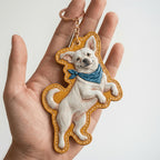 Dog-shaped keychain with a white dog design on a plain background