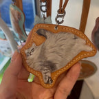 Leather Cat-shaped keychain with a cat's face on a brown leather-like material.
