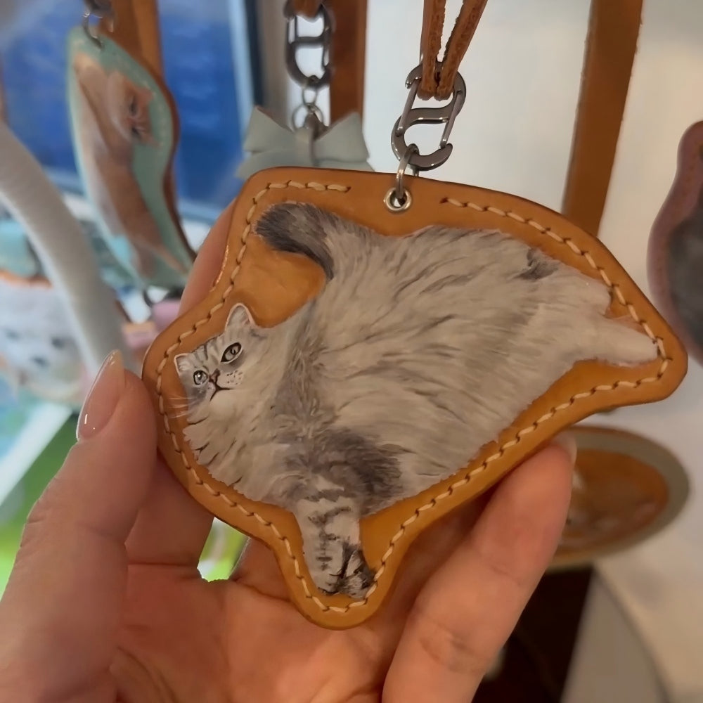 Leather Cat-shaped keychain with a cat's face on a brown leather-like material.
