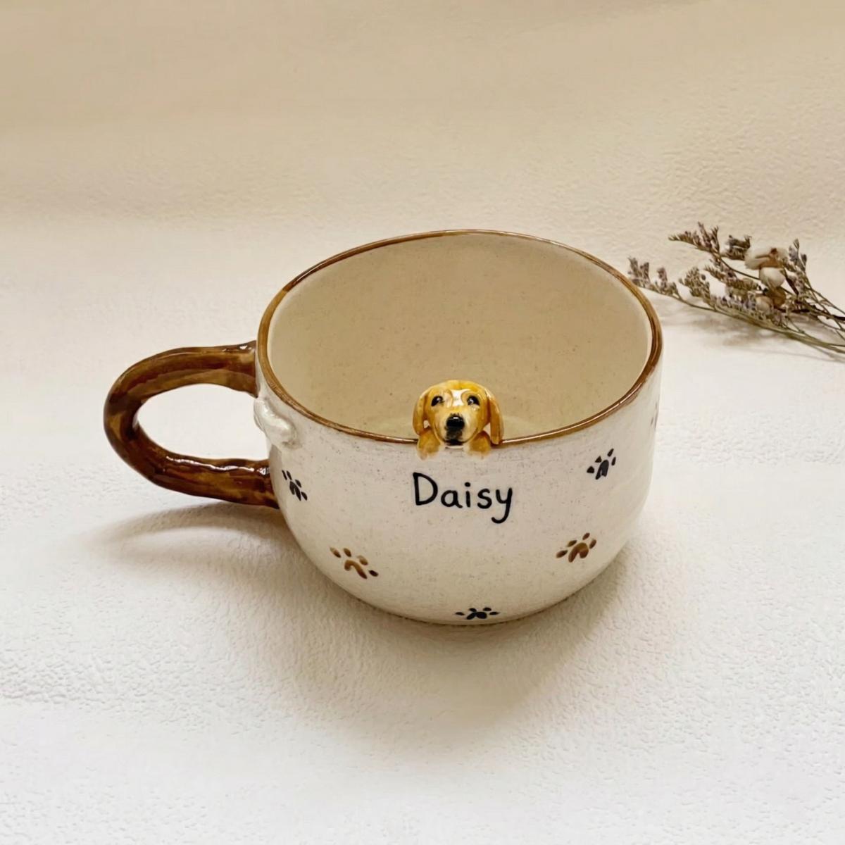 Ceramic mug with a dog figurine and 'Daisy' on a light background