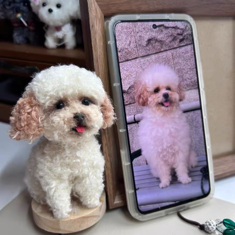 Small dog sitting next to a smartphone displaying an image of another dog.