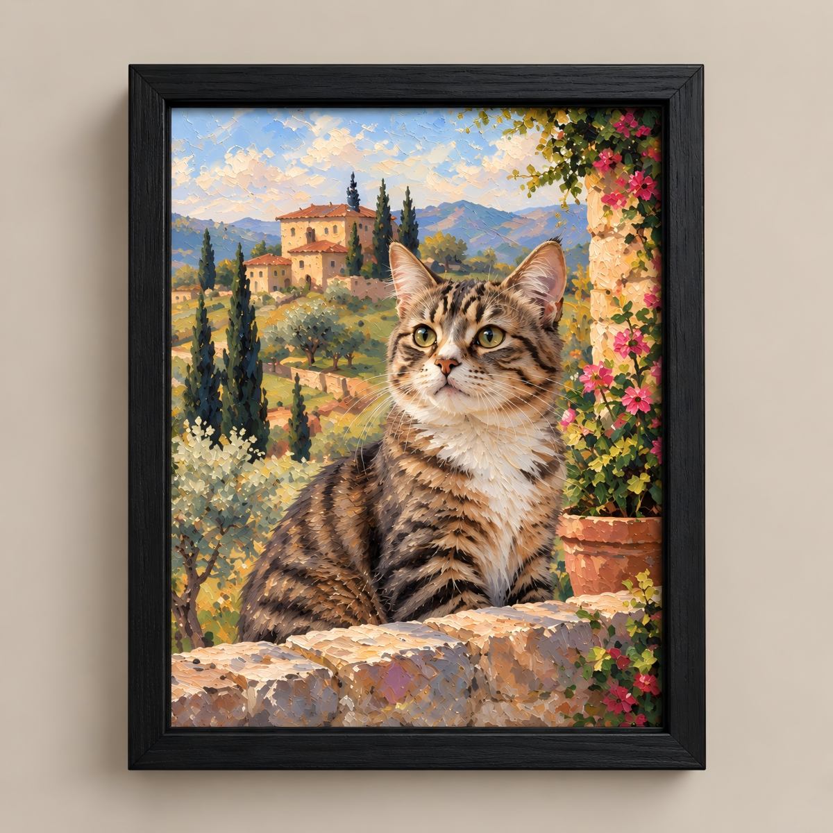 Framed canvas wall art featuring a painted tabby cat sitting on a stone wall with a scenic landscape background, shown hanging on a beige wall.