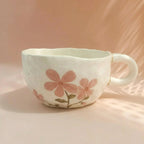 Ceramic mug with pink floral design on a soft pink background