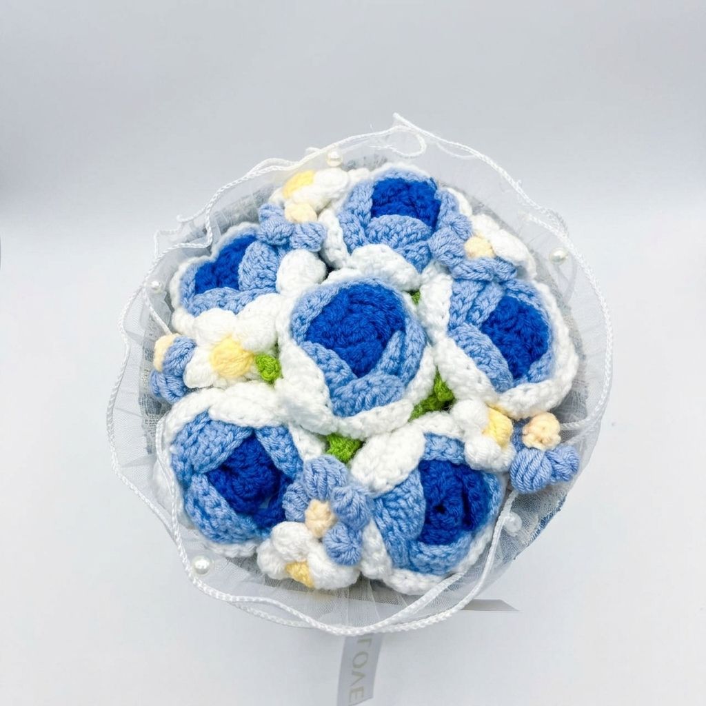 Bouquet of blue and white crocheted flowers on a light gray background