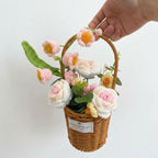 Handmade flower basket with pink and white flowers held by a hand on a white background