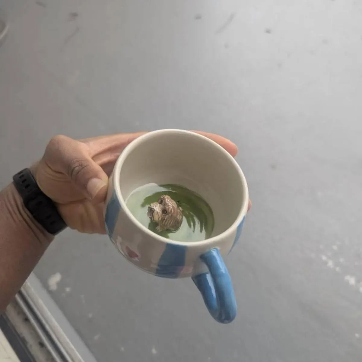 Custom ceramic mug with blue stripes and a small dog figurine inside on a white background
