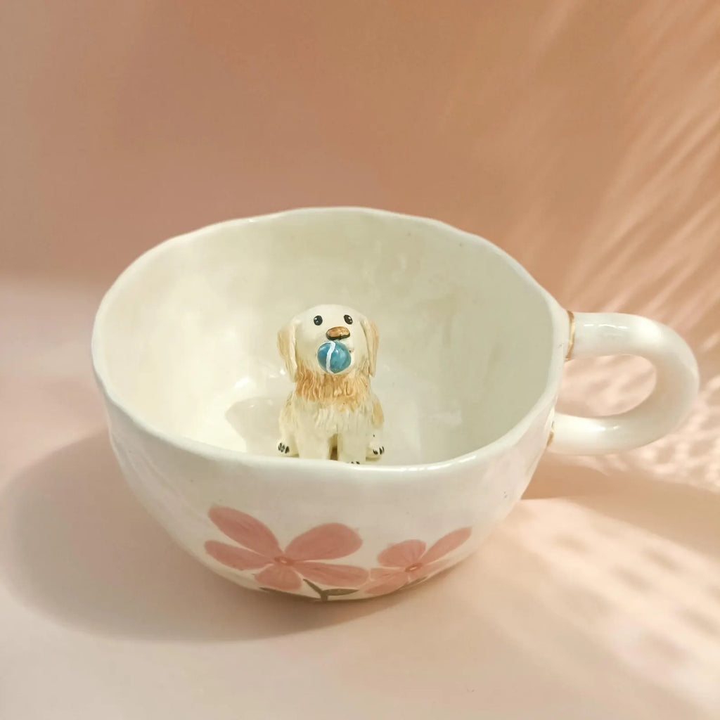 Small dog figurine inside a floral-patterned mug on a soft pink background