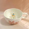 Small dog figurine inside a floral-patterned mug on a soft pink background