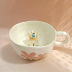 Small dog figurine inside a floral-patterned mug on a soft pink background