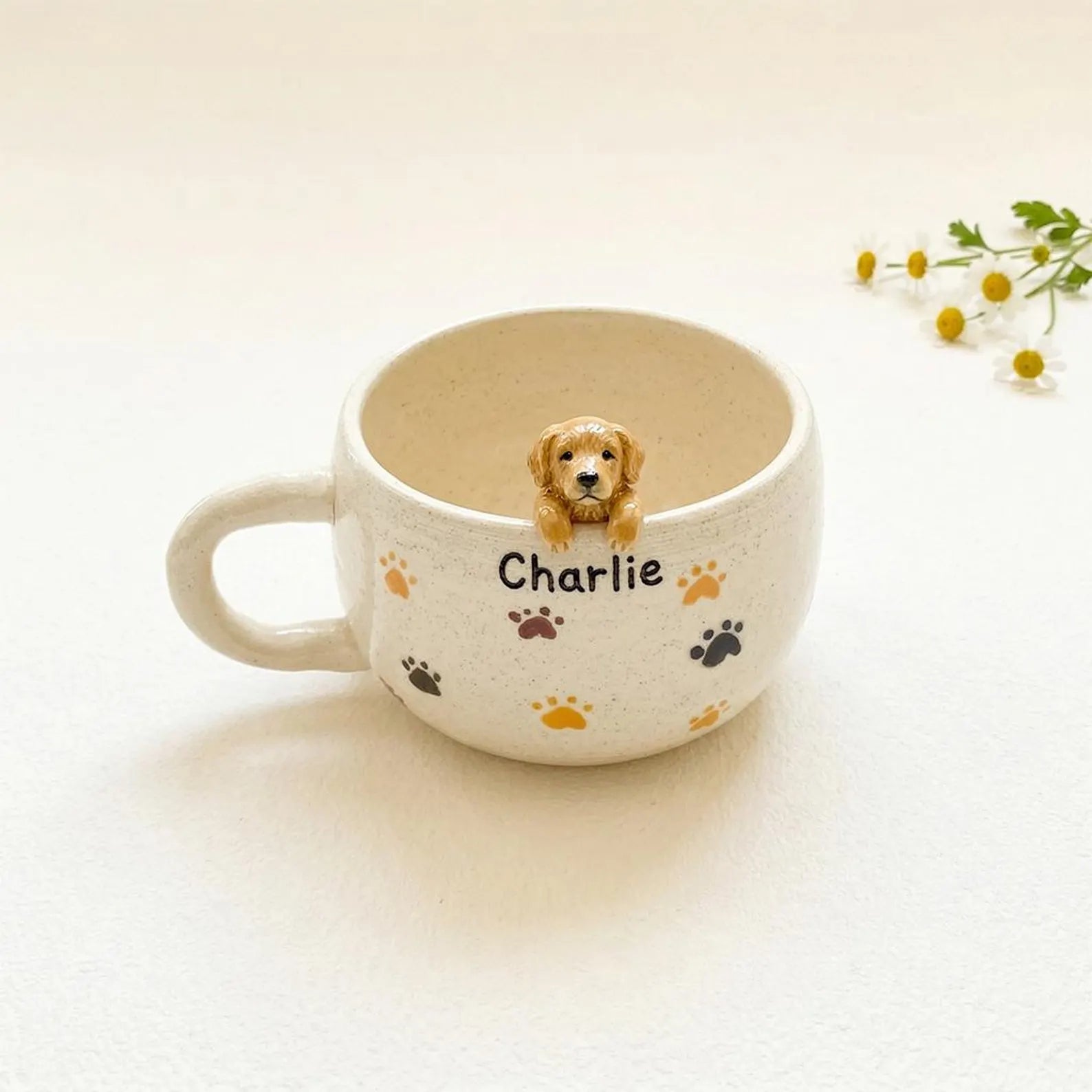 Ceramic mug with a small dog figurine and 'Charlie' text on a light background
