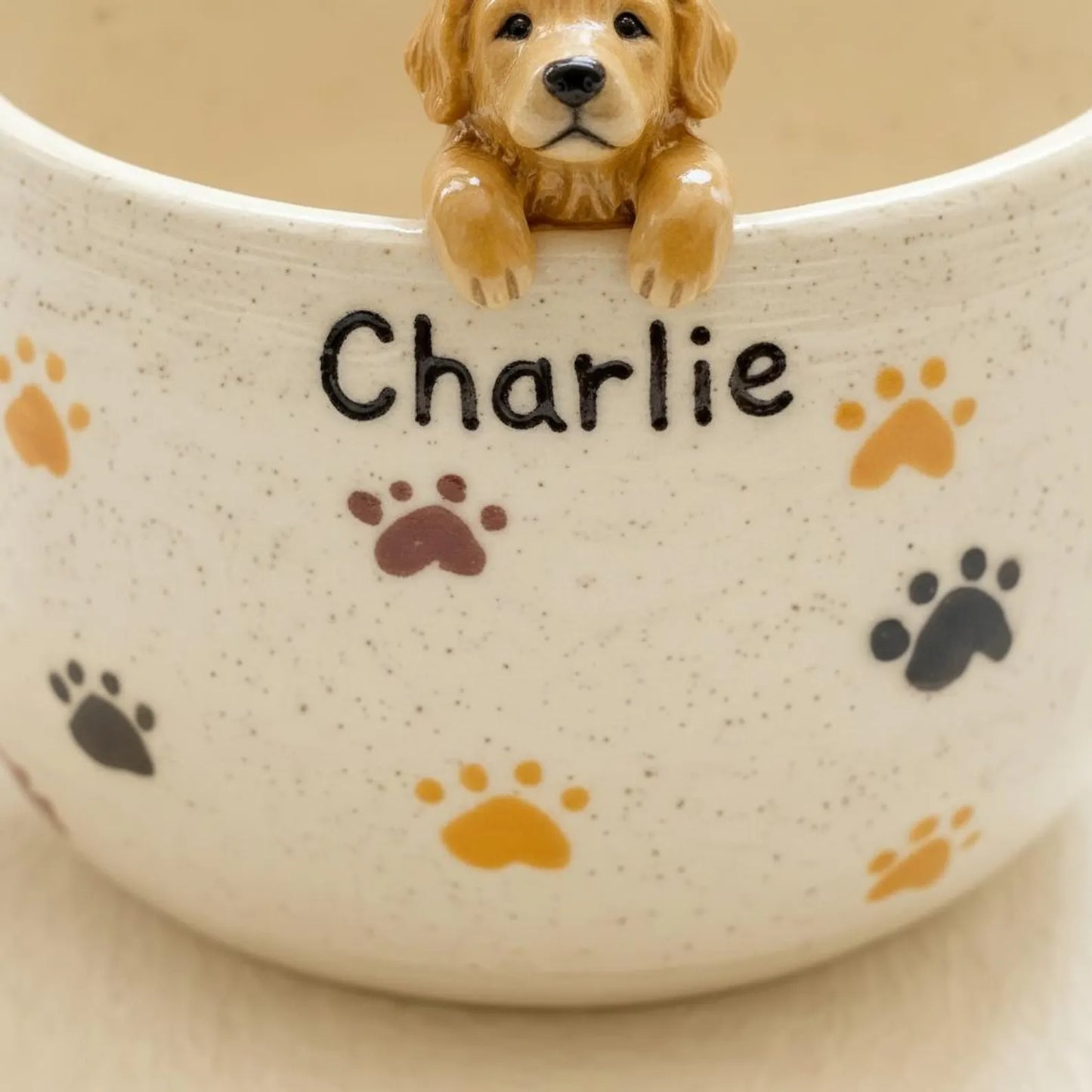 Ceramic bowl with 'Charlie' and paw prints, featuring a small dog figurine.