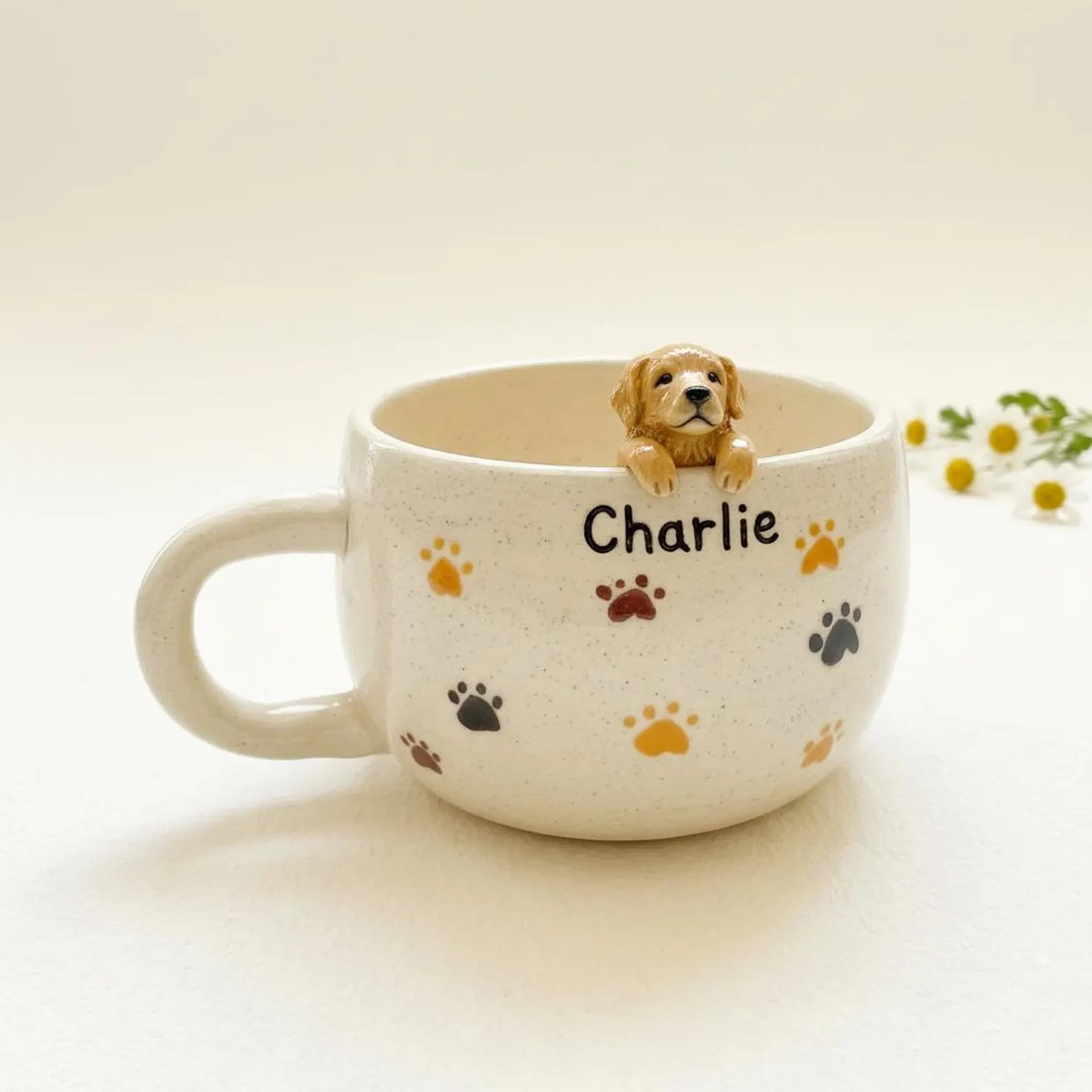 Custom pet ceramic mug with 'Charlie' and paw prints, featuring a small dog figurine on a light background.
