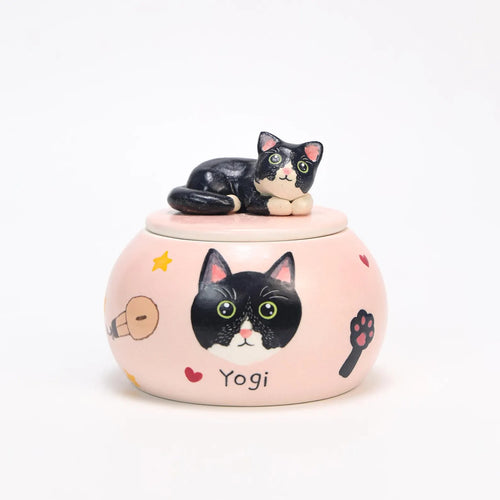 Custom pink ceramic urn with black cat design and 'Yogi' text on a white background