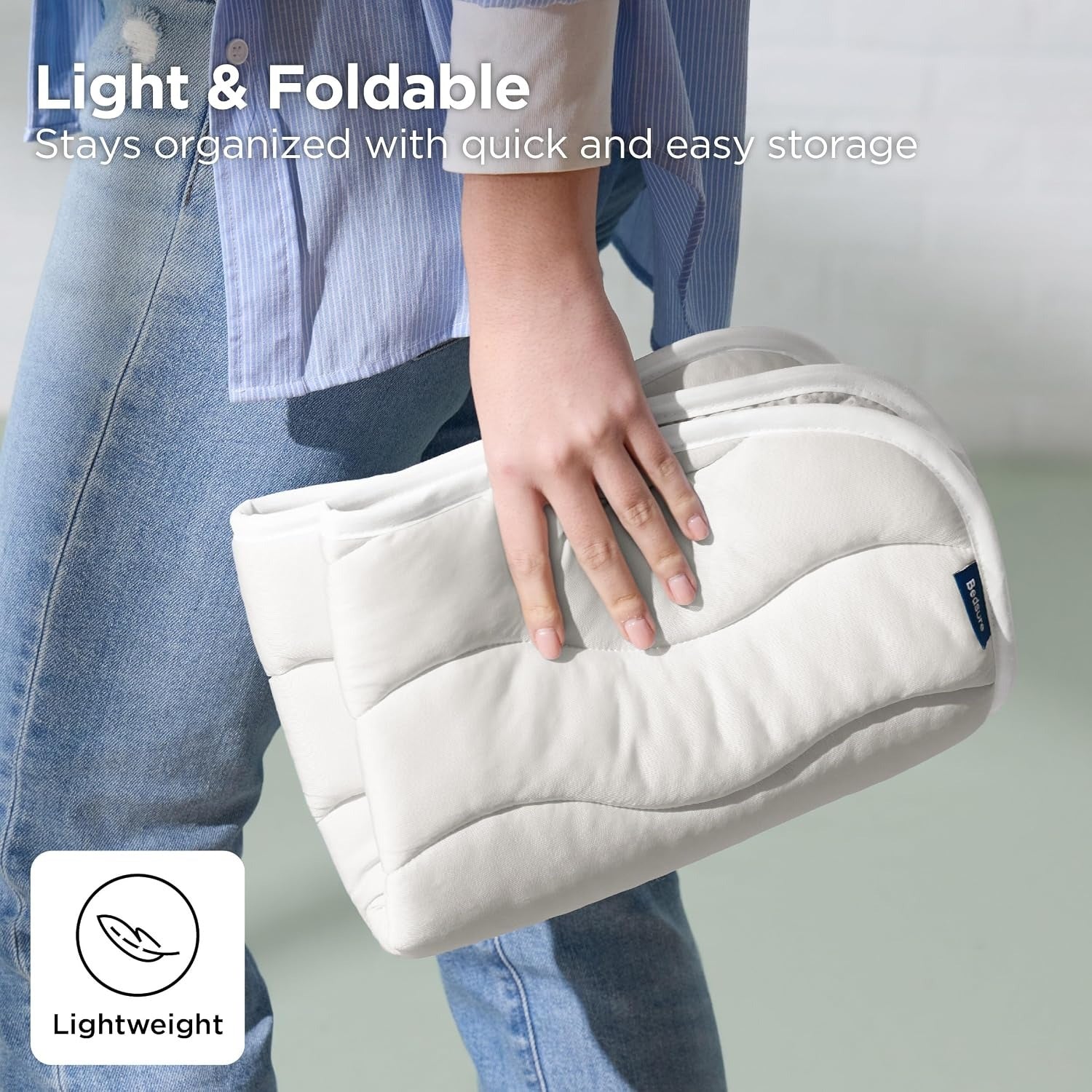 White foldable bag held by a person wearing blue jeans, with text highlighting its light weight and ease of storage.