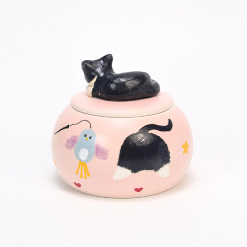Custom pink ceramic urn with black cat design and 'Yogi' text on a white background