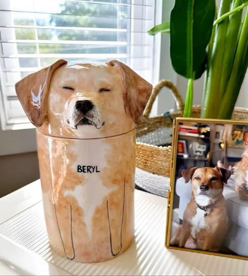Dog-shaped ceramic jar with 'BERYL' on a surface, next to a photo of a dog.