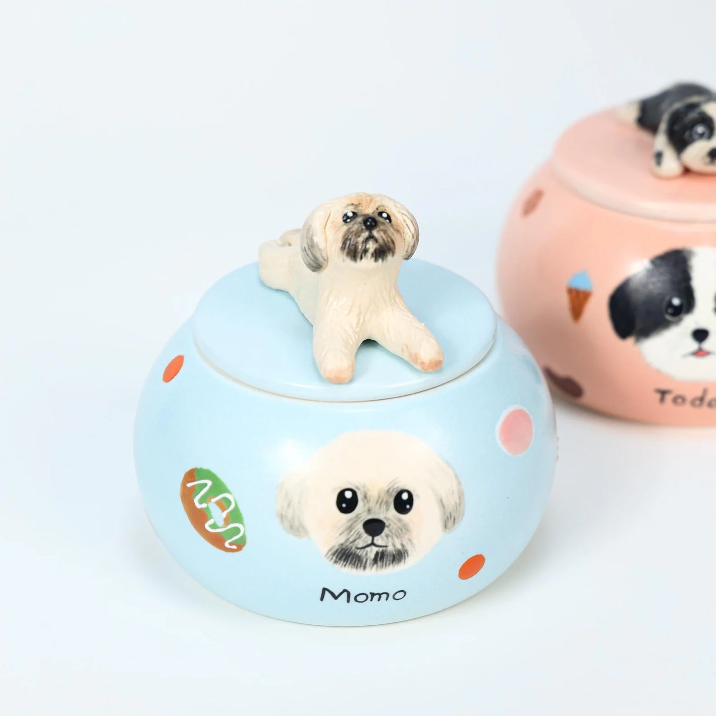 Ceramic jar with a dog figurine on top and another dog illustration on a light blue background.